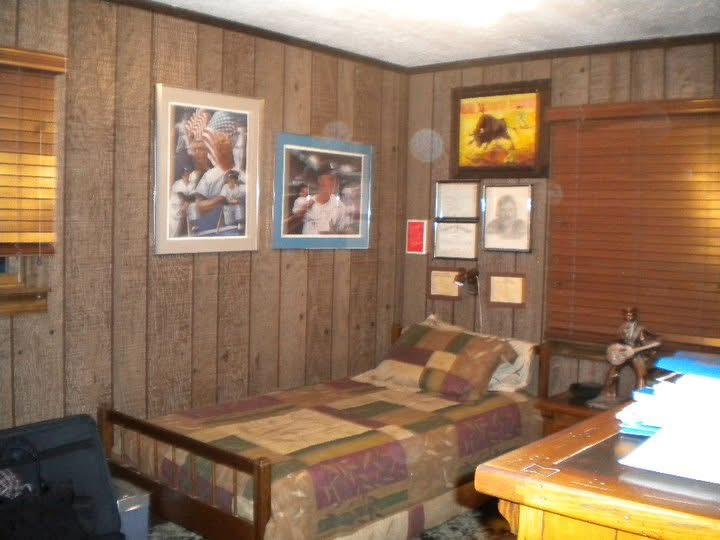 Secondary bedroom before the work began, with dark wood paneling, old furniture and personal belongings still in place