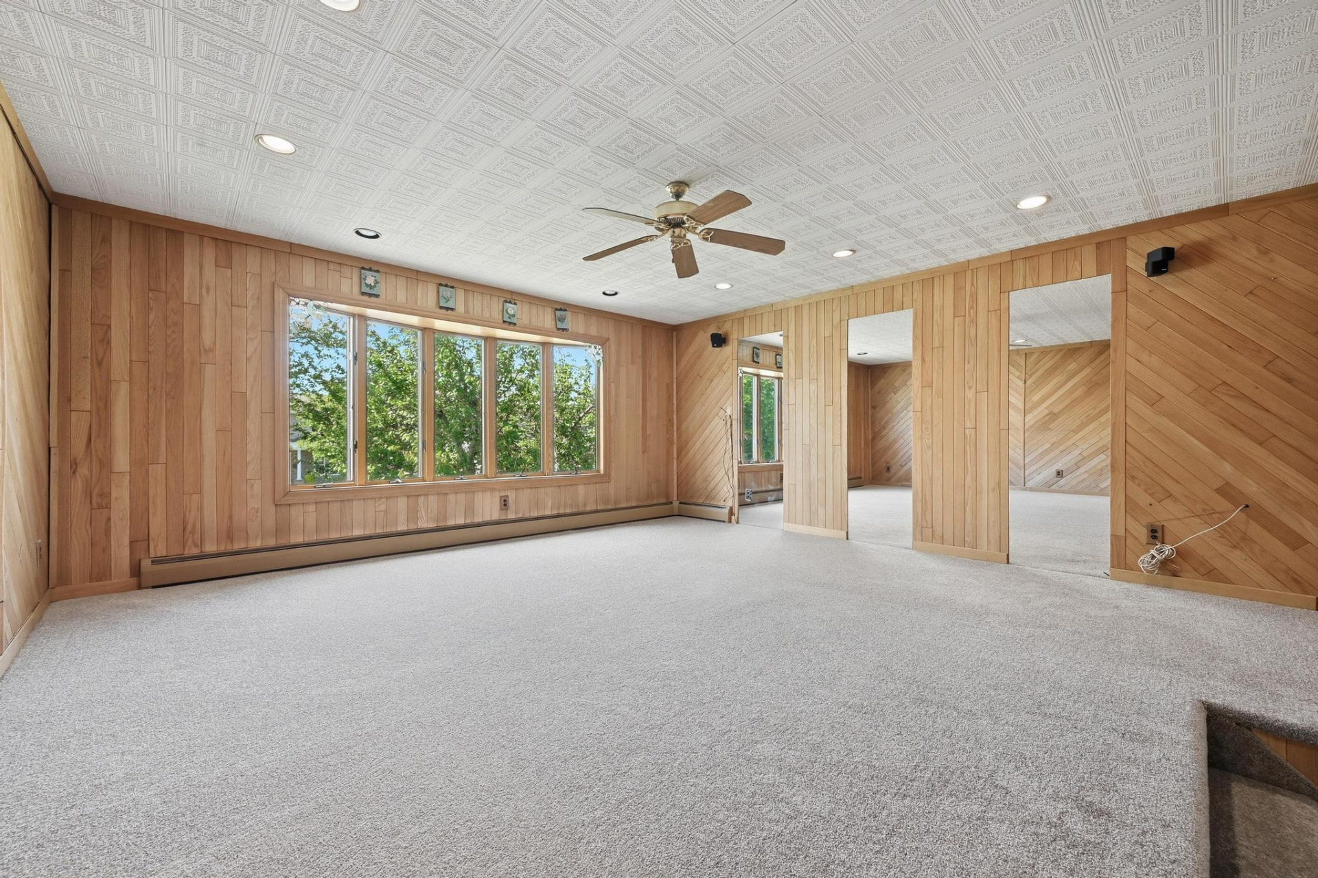 The same living room after the work, with new carpet and a bright, finished ceiling